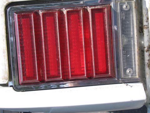 1991 Ford LTD Crown Victoria - Close-up of a vehicle's red ribbed tail light assembly with a clear reverse light section.