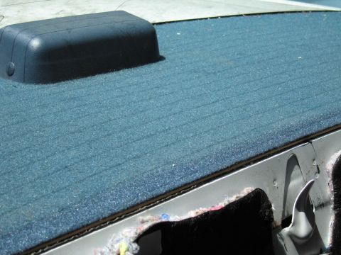 1991 Ford LTD Crown Victoria - Close-up of a car's interior, showing blue carpet and a dark plastic component.