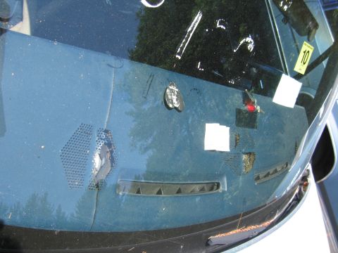 1991 Ford LTD Crown Victoria - The interior of a vehicle shows a cracked windshield and a yellow inspection sticker with the number 10.
