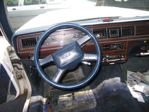 1991 Ford LTD Crown Victoria - The interior of a 1991 Ford Crown Victoria LTD features wood grain trim and a blue steering wheel.