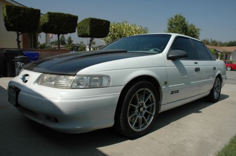 1993 Ford Taurus - This 1993 Ford Taurus has a custom black hood and aftermarket wheels.