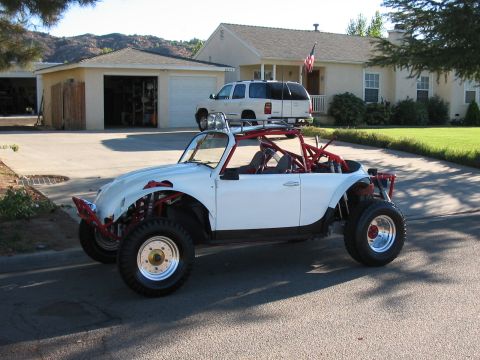 1990 Ford Bronco - white VW Beetle off-road buggy with a red roll cage and knobby tires sits in a suburban driveway near a flag.