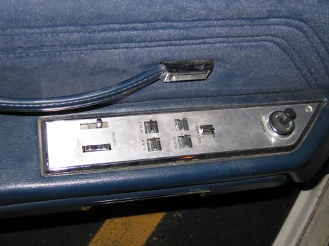 1991 Ford LTD Crown Victoria - Close-up of a car's interior door panel, showing power window and lock controls.