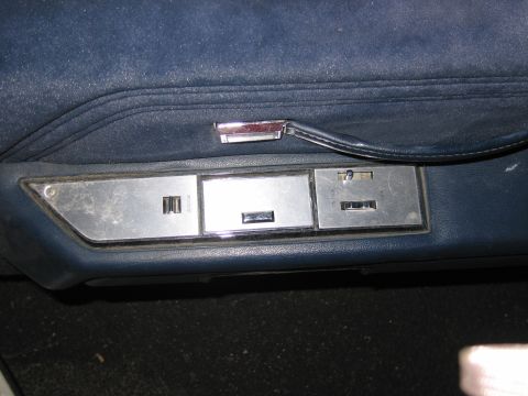 1991 Ford LTD Crown Victoria - Close-up of the power window and lock controls on a blue interior door panel.