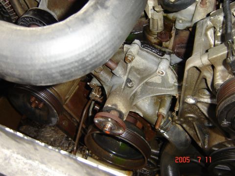 1993 Ford Bronco - Close-up of a vehicle's engine water pump and associated components, with visible fluid leakage.