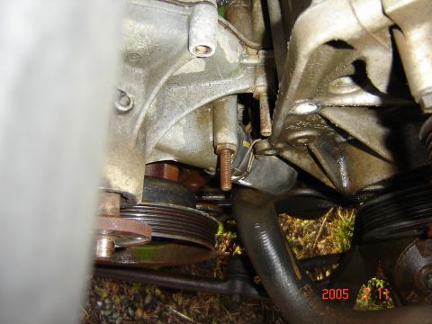 1993 Ford Bronco - This image shows a close-up view of an engine's water pump and associated pulleys, with visible signs of wear and fluid leakage.