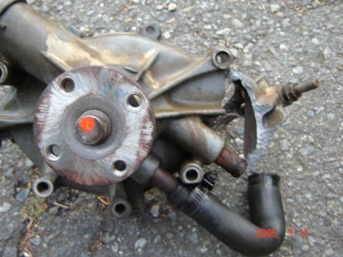 1993 Ford Bronco - This image shows a damaged water pump, likely from a Ford Bronco, with a broken flange and a hose still connected.