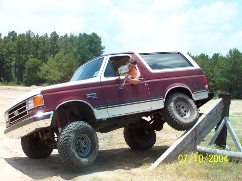 1987 Ford Bronco - A Ford Bronco navigates an off-road course, demonstrating its capabilities on uneven terrain.