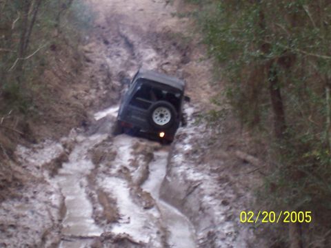 1987 Ford Bronco - A vehicle navigates a difficult, muddy off-road path.
