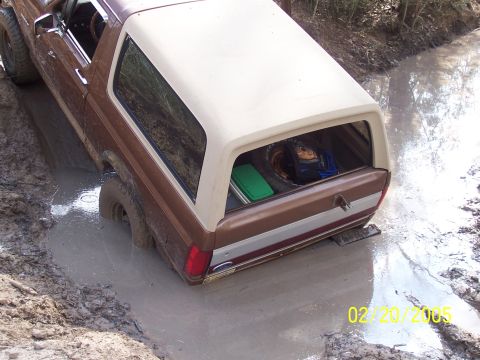 1987 Ford Bronco - This 1987 Ford Bronco is stuck in a muddy ditch, with its rear end submerged.