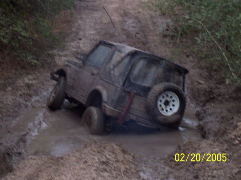 1987 Ford Bronco - Off-road vehicle stuck in mud puddle on a dirt track, date stamp 02/20/2005.