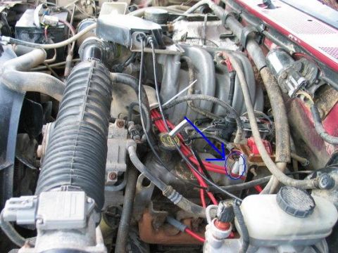 1995 Ford Bronco - Close-up view of a vehicle's engine compartment, showing various hoses, wires, and mechanical parts.