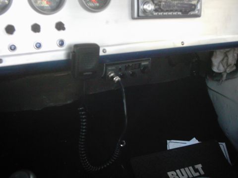 1978 Ford Bronco - A close-up view of a vehicle's dashboard reveals gauges and a CB radio unit.