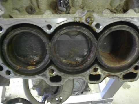 1993 Ford Probe - The internal components of an engine block are visible, with three cylinders showing signs of damage and corrosion.