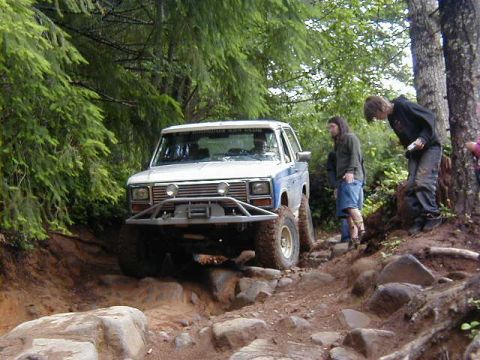1994 Ford Explorer - A modified truck navigates a challenging, rocky off-road course with onlookers observing the action.