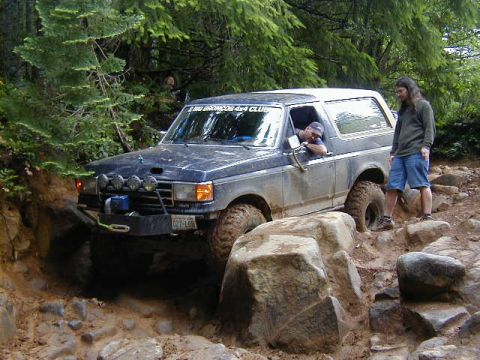 1994 Ford Explorer - Ford Bronco tackles a challenging off-road course, demonstrating its capability on rough terrain.
