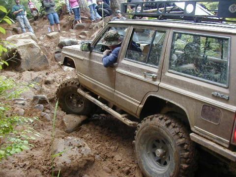 1994 Ford Explorer - This 1994 Ford Explorer is tackling a challenging off-road course with onlookers observing the action.