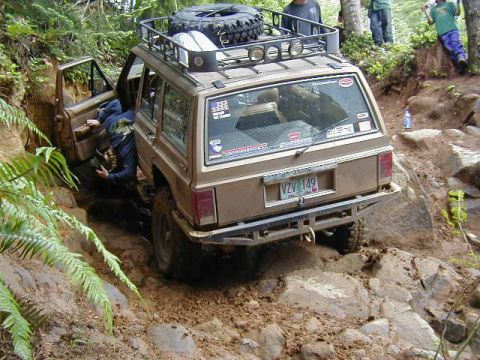 1994 Ford Explorer - This SUV is attempting to climb a challenging off-road trail with steep rocks and mud.