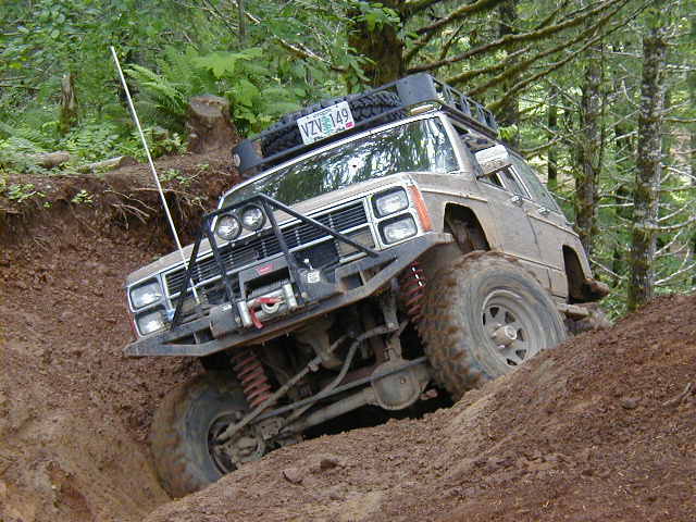1994 Ford Explorer climbing a steep dirt incline, front grille and winch visible