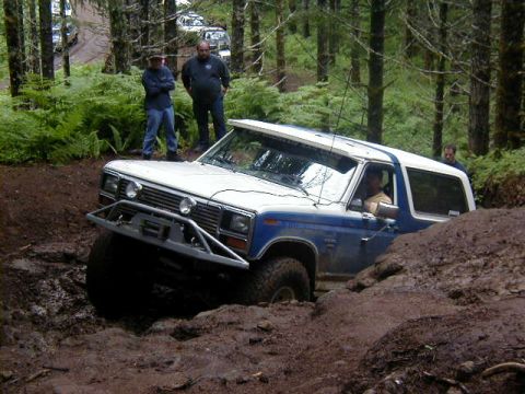 1994 Ford Explorer - Ford Bronco navigating a challenging muddy obstacle on an off-road trail.