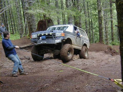 1994 Ford Explorer - A man pulls a Ford Bronco out of the mud during an off-road event.