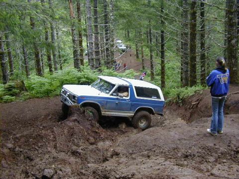 1994 Ford Explorer - Multiple vehicles navigate a muddy off-road course in a forest.