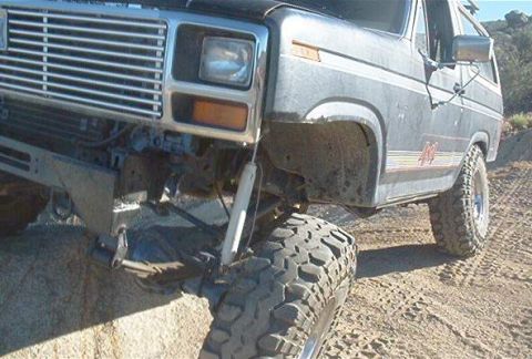 1986 Ford Bronco - This 1980s Ford Bronco shows off its off-road capabilities with large tires and lifted suspension on a dirt path.