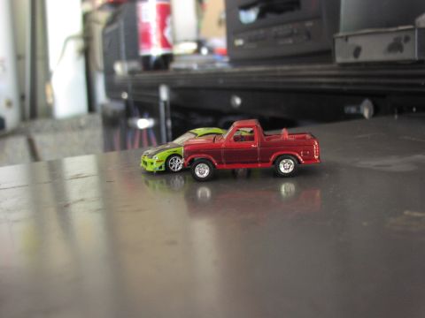1979 Ford Bronco - Two toy vehicles are parked side-by-side on a reflective surface.