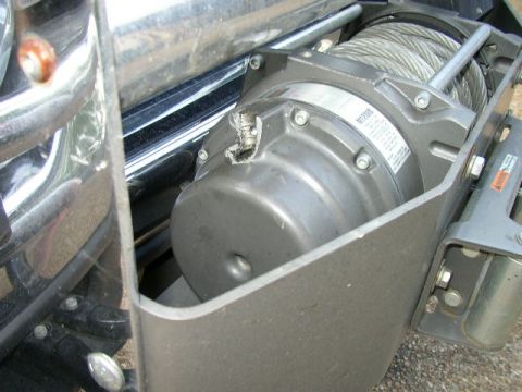 1995 Ford Bronco - Close-up view of a winch and steel cable attached to the front of a vehicle.
