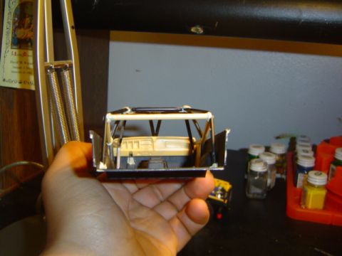 1979 Ford Bronco - A hand holds a model car interior, showing the dashboard and roll cage details.