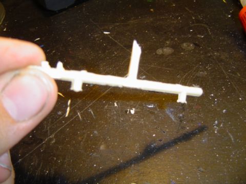 1979 Ford Bronco - Plastic model sprue with parts being held by a hand over a workbench.