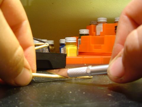 1979 Ford Bronco - Someone is carefully cutting a small piece of material with a craft knife, likely for a model project.