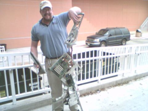 1993 Ford Bronco - Man holds computer tower parts outside near a dark SUV.