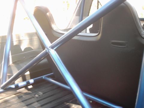 1978 Ford Bronco - Roll cage and seat installed inside a vehicle's interior.