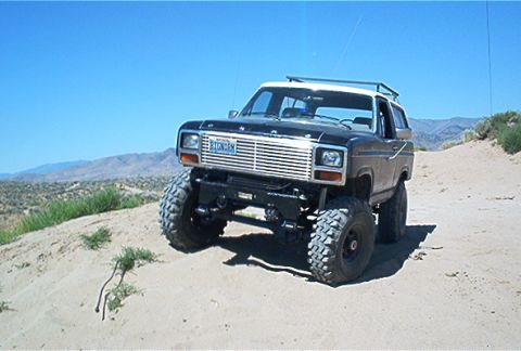 1986 Ford Bronco - This modified SUV is shown off-road with a prominent grille and large tires.