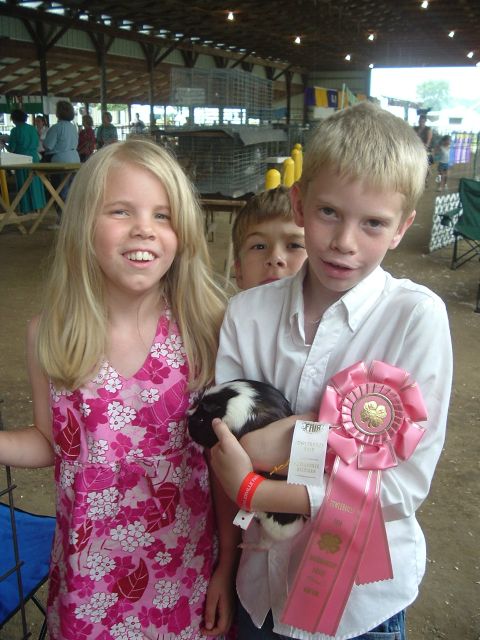 1989 Ford Bronco - Three children pose with a guinea pig and award ribbons at an outdoor event, possibly a fair or competition.