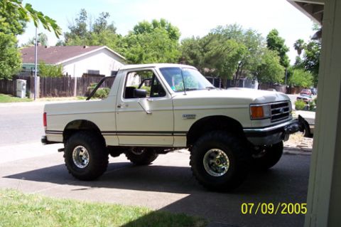1995 Ford Bronco - White full-size Ford Bronco with the rear top removed, parked in a suburban driveway and shot from the driver's-side front three-quarter. I…