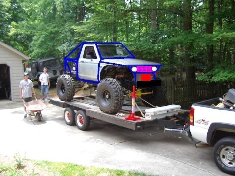 1985 Ford Bronco - A heavily modified pickup truck is loaded onto a trailer, ready for transport.