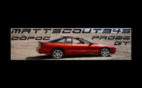 1996 Ford Probe - Side view of a red 1996 Ford Probe GT parked in a dusty, outdoor setting.