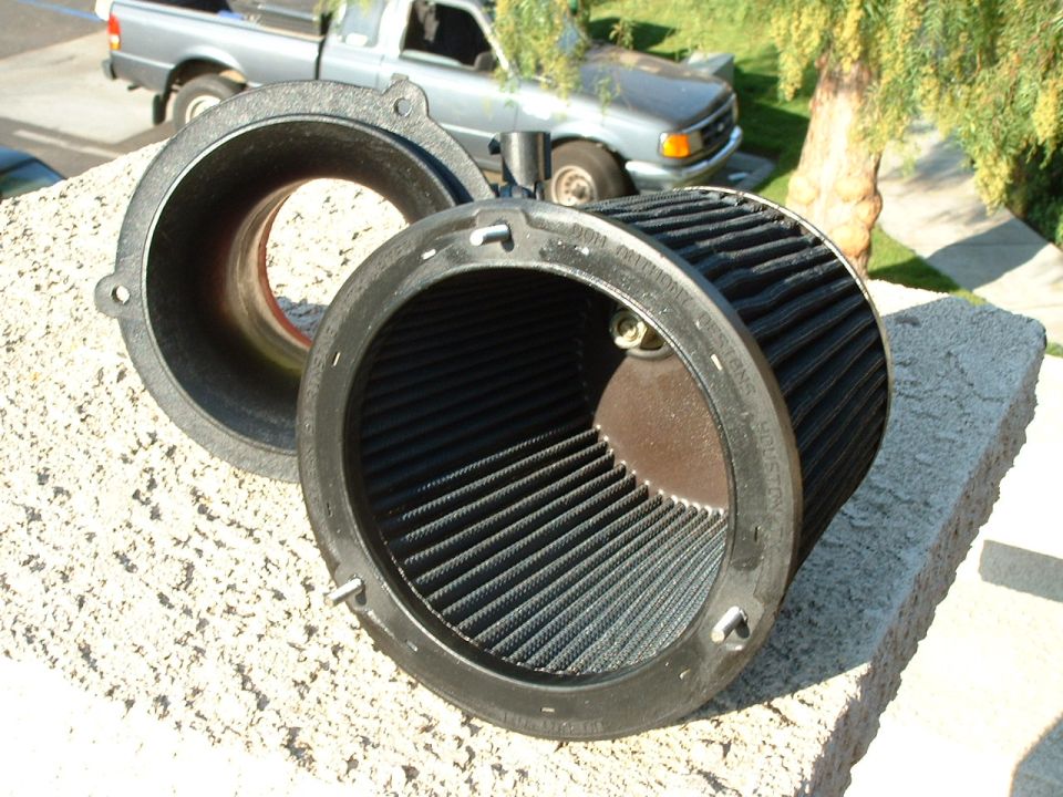 engine air filter assembly on a wall, with a pickup truck in the background