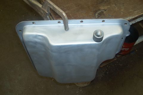 1983 Ford Bronco - A metal oil pan with a threaded drain plug fitting is clamped in place, ready for service.