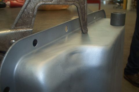 1983 Ford Bronco - A metal oil pan is secured with a clamp, showing its shape and mounting holes.