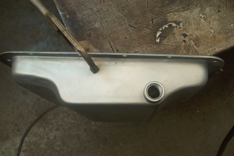 1983 Ford Bronco - An oil pan with a drain plug is shown with a chisel, alongside a Supermotors.net logo.