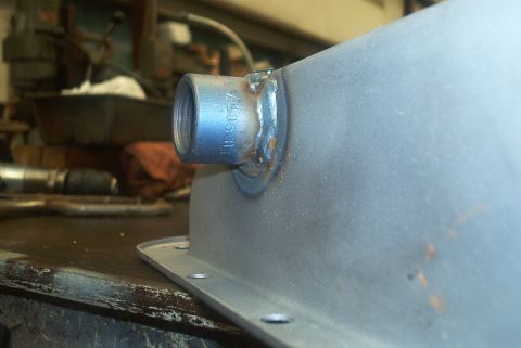 1983 Ford Bronco - A close-up view of a metal part a welded threaded fitting and visible stamped numbers.