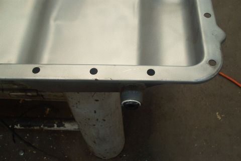 1983 Ford Bronco - Close-up of a transmission pan showing the drain plug fitting.