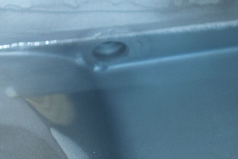 1983 Ford Bronco - Close-up view of a drain plug hole on a blue metal surface, with SuperMotors.net watermark visible.