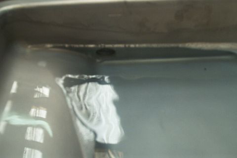 1983 Ford Bronco - A close-up view of the underside of a vehicle, showing a white cloth secured with a black tie.