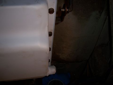 1983 Ford Bronco - Underside view of a vehicle's oil pan, focusing on the drain plug and surrounding bolts.