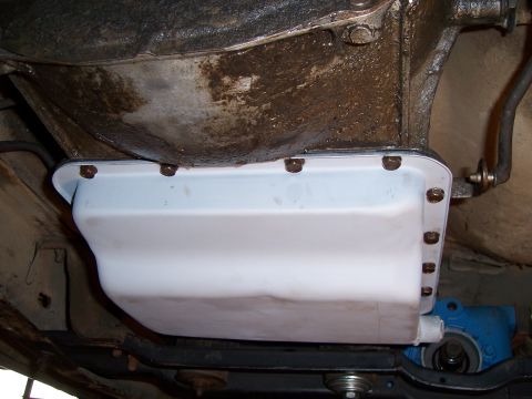 1983 Ford Bronco - Close-up of a clean transmission oil pan, showing its attachment bolts and surrounding undercarriage components.
