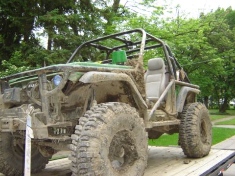 1992 Ford Bronco - This heavily modified off-road vehicle is covered in mud, suggesting recent use on rough terrain.